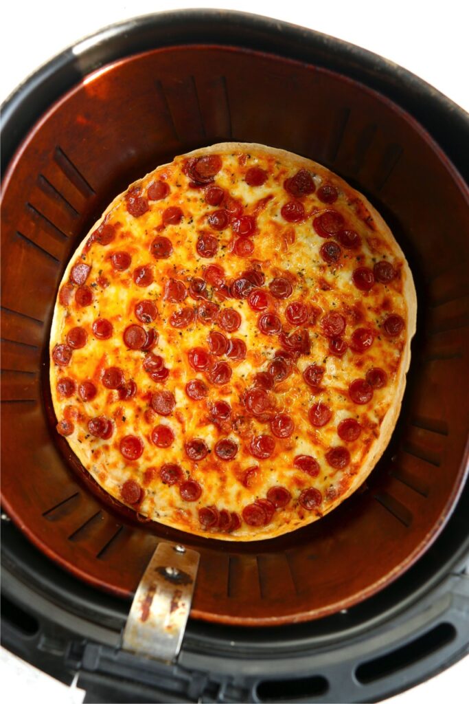 Overhead shot of cooked tortilla pizza in air fryer
