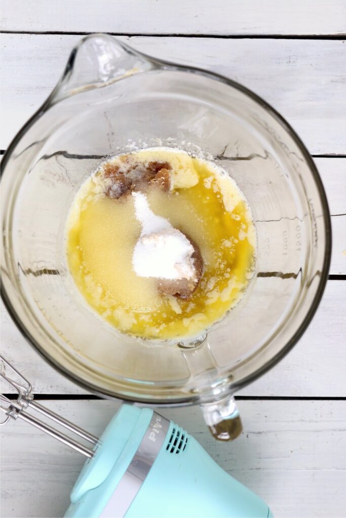 Overhead shot of melted butter, white sugar, and brown sugar in bowl