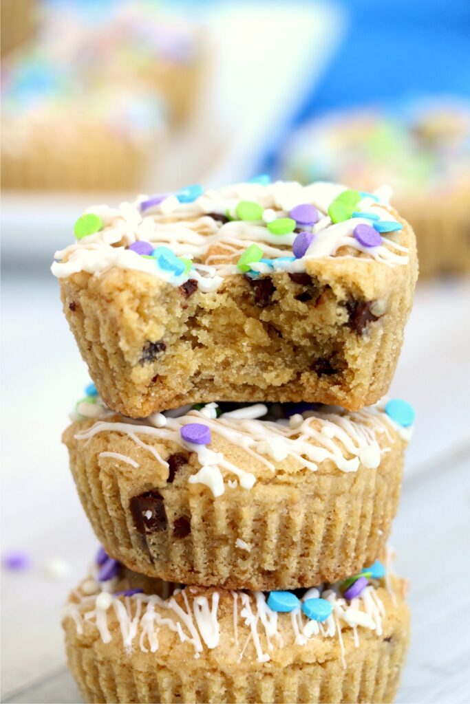 Chocolate chip cookie muffins stacked atop one another with bite taken out of top