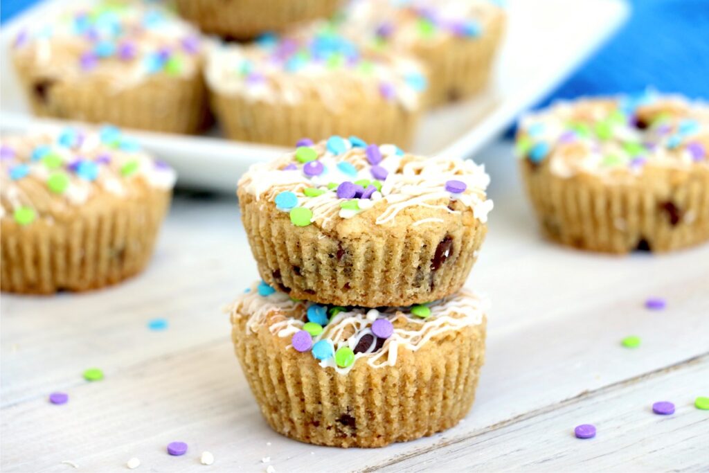 Closeup shot of muffin tin chocolate chip cookies stacked atop one another with more cookies in background