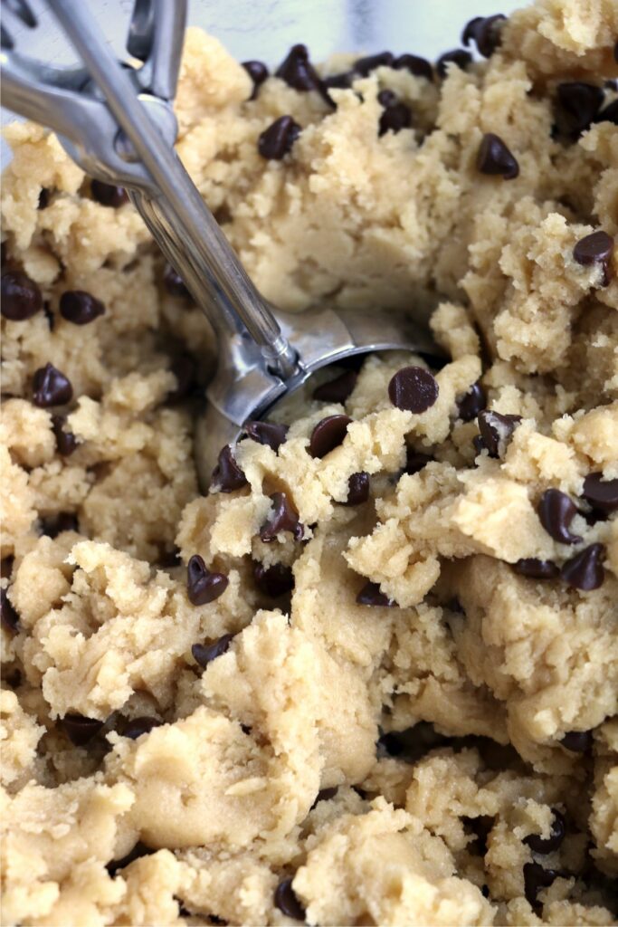 Closeup shot of cookie scoop scooping out chocolate chip cookie dough