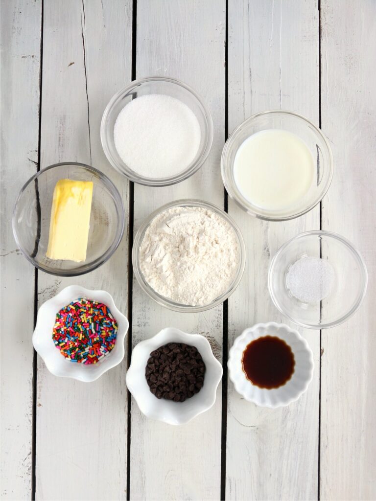 Overhead shot of cookie dough dip ingredients in individual bowls on table