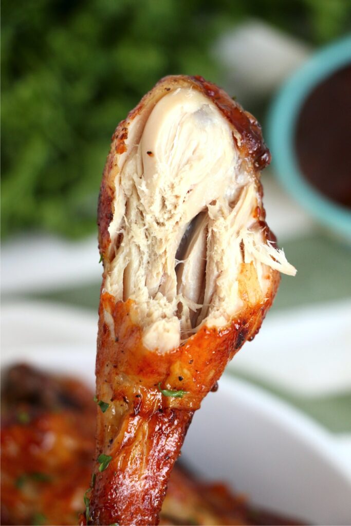 Closeup shot of crock pot bbq chicken drumstick with bite taken out