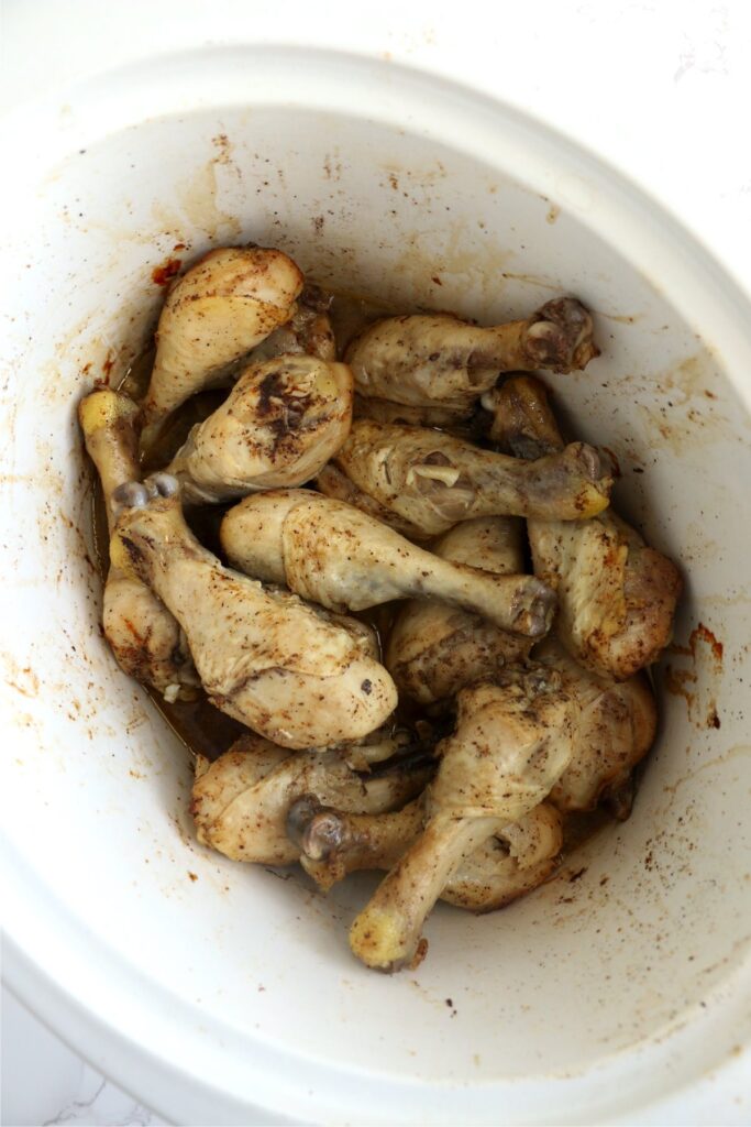 Overhead shot of cooked drumsticks in crock pot