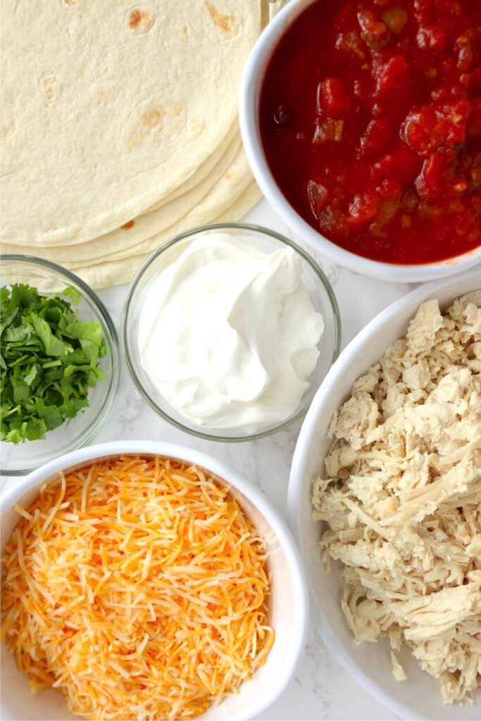 Overhead shot of wrap ingredients in individual bowls on table