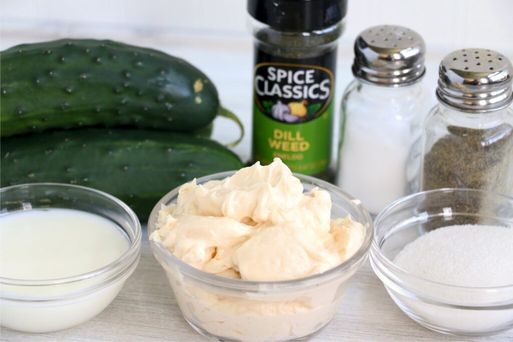 Cucumbers and individual salad ingredients on table