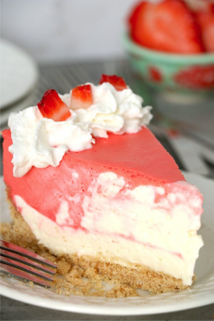 Closeup shot of slice of no-bake strawberry jello cheesecake on plate