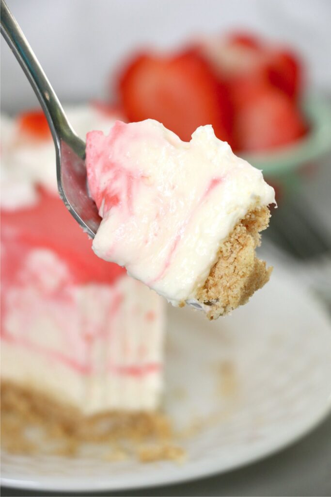 Closeup shot of forkful of no-bake strawberry jello cheesecake