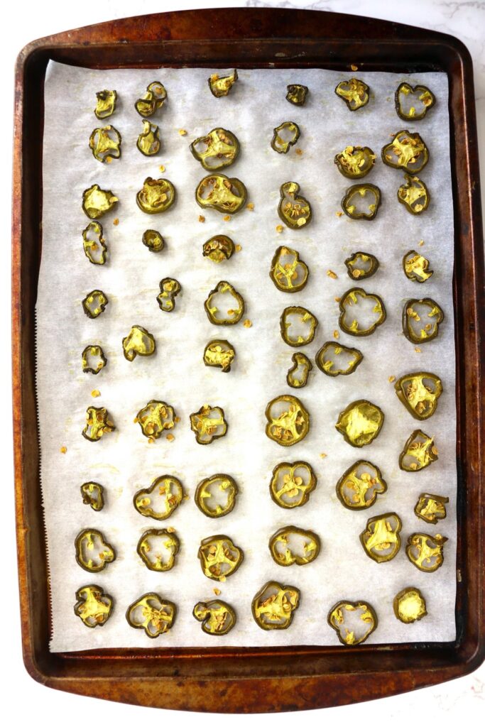 Overhead shot of dried jalapenos on baking sheet lined with parchment paper