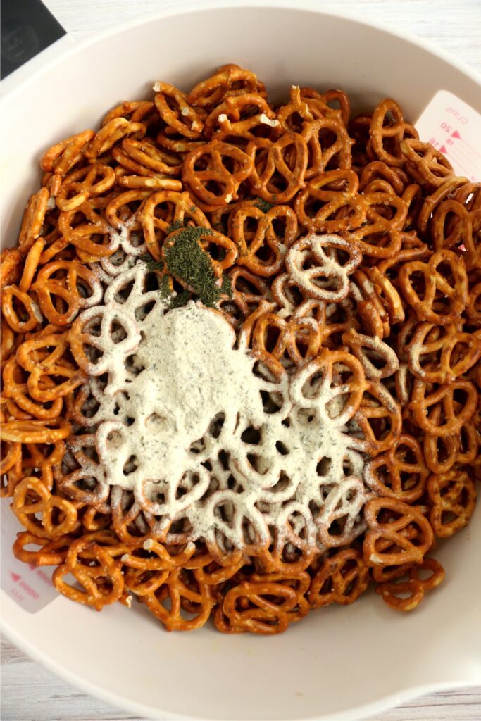 Overhead shot of spices thrown into bowl of pretzels