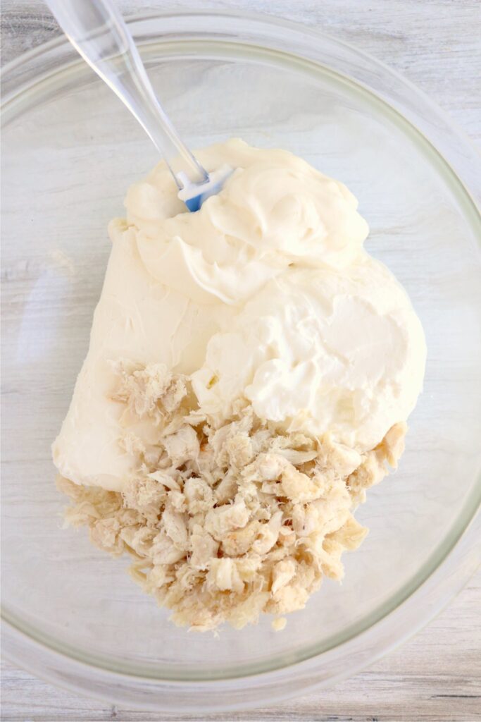 Overhead shot of crab, cream cheese, sour cream, and mayo in mixing bowl