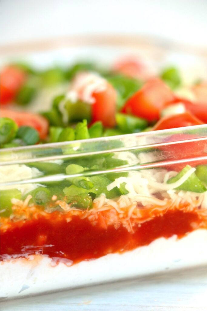 Closeup shot of layered seafood cheese dip in baking dish