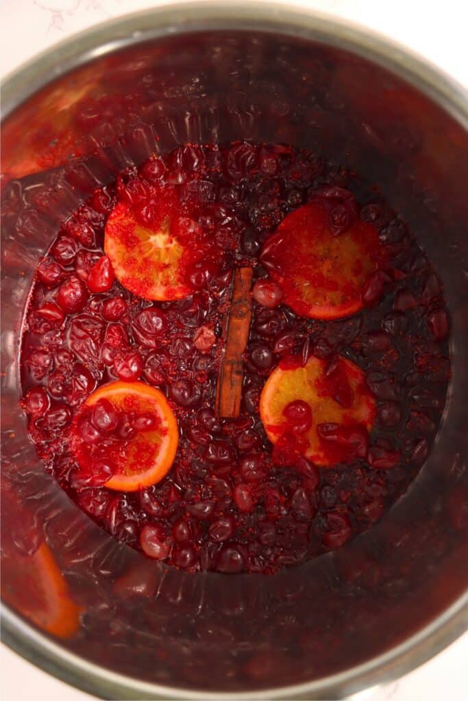 Overhead shot of cranberries, orange slices, and cinnamon stick cooked in Instant Pot.