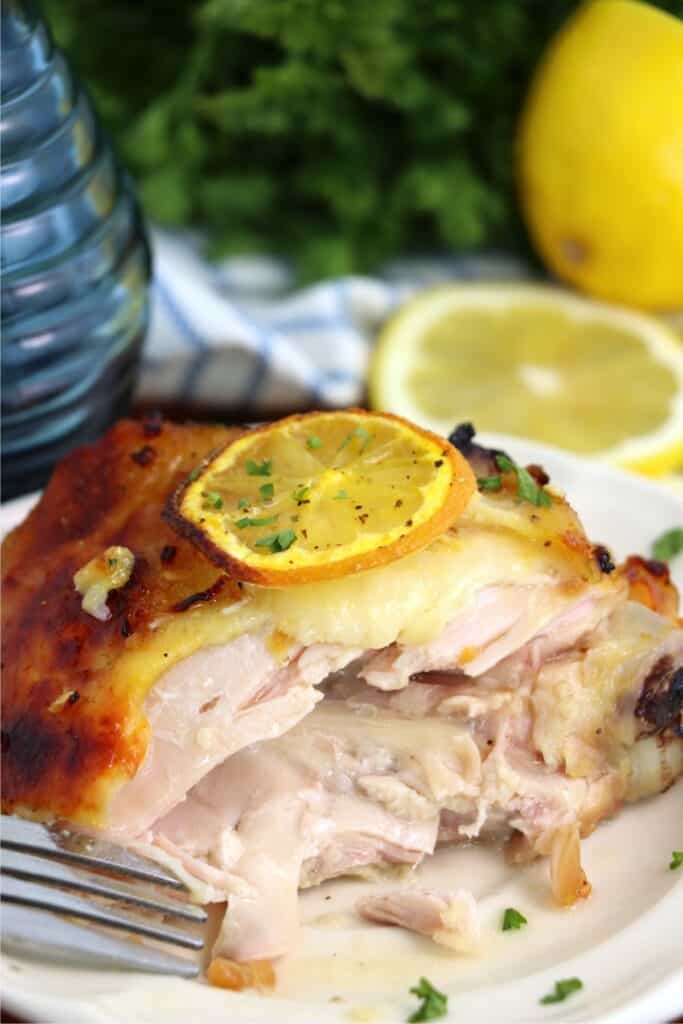 Closeup shot of honey garlic lemon pepper chicken thigh with bite taken out on plate