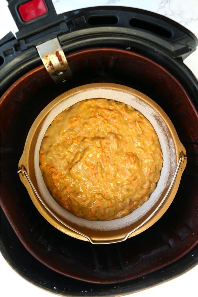 Overhead shot of carrot cake batter in baking dish inside air fryer