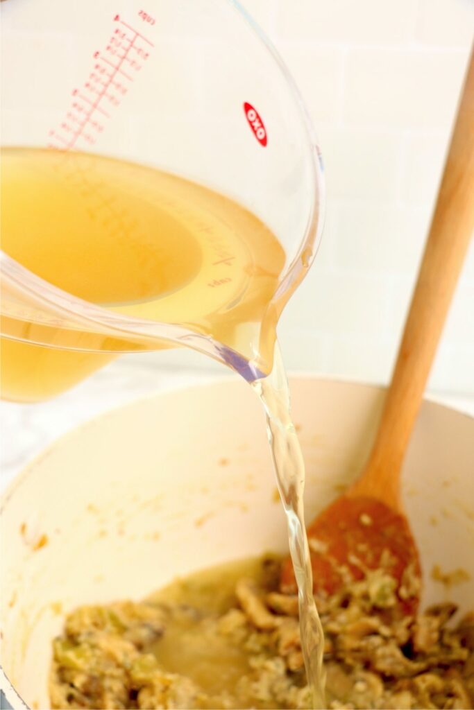 Broth boing poure into pot of vegetables.