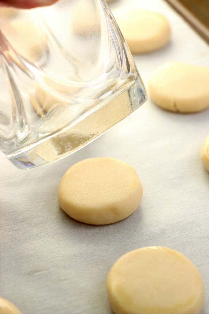 Closeup shot of cookie dough balls being flattend with a glass