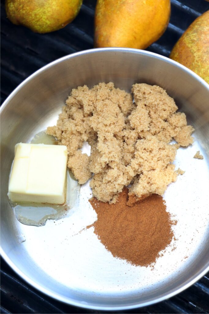 Overhead shot of butter, brown sugar, and cinnamon in saucepan on grill