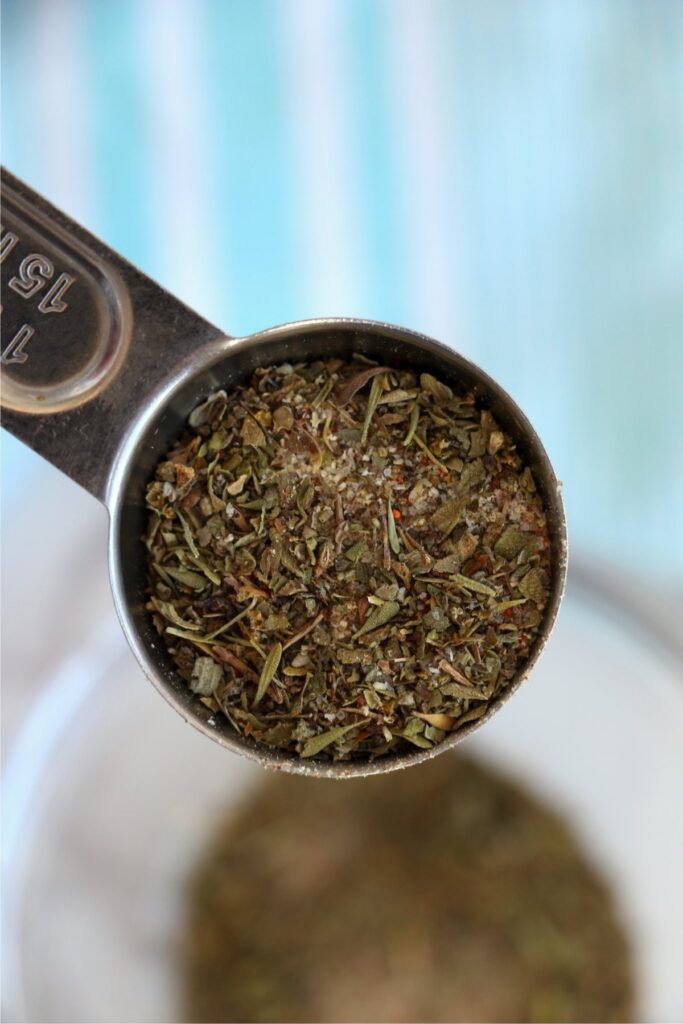 Overhead closeup shot of measuring spoon full of meatloaf seasoning.