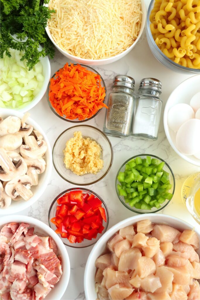 Overhead shot of individual rigatoni carbonara ingredients in bowls on table