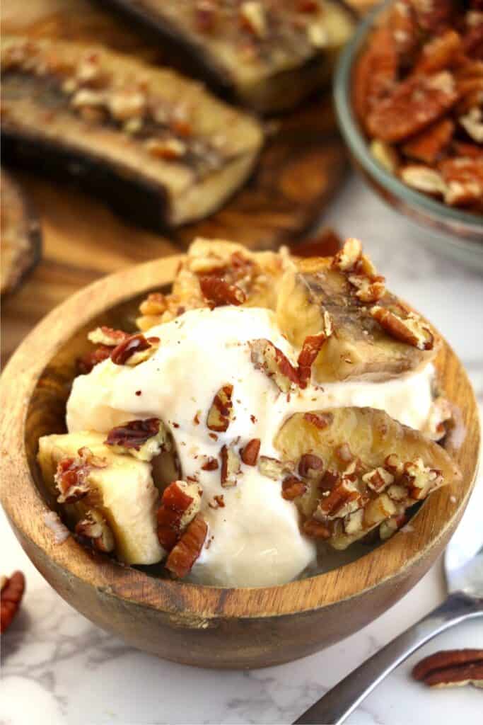 Closeup shot of bowlful of ice cream topped with air fryer bananas