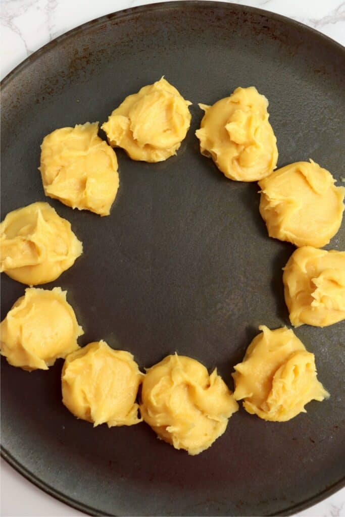 Overhead shot of raw cream puff dough on baking sheet