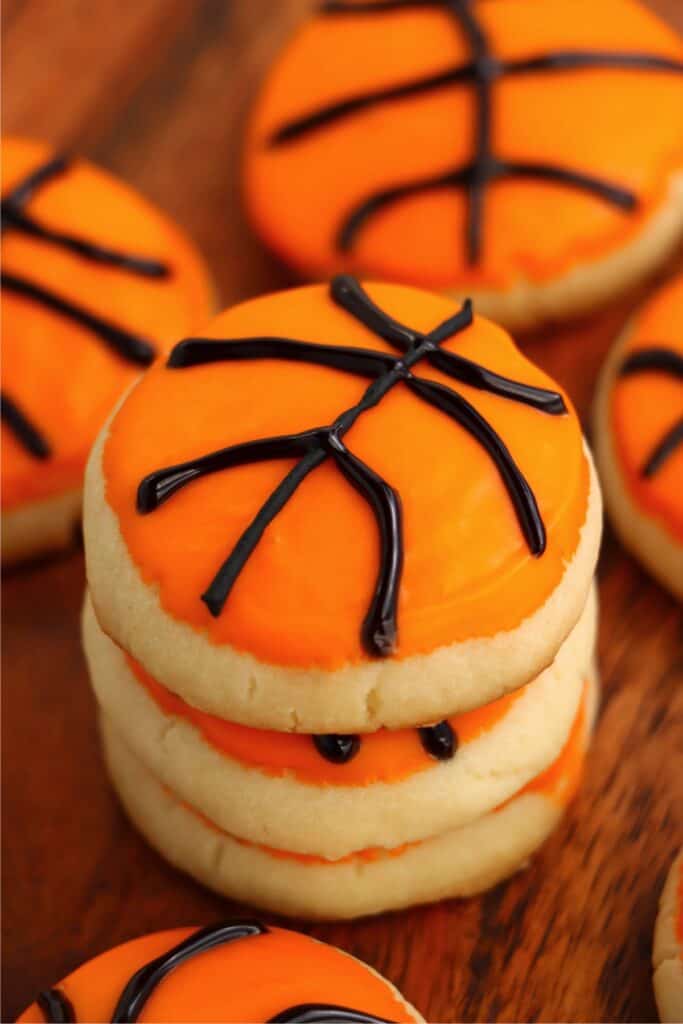 Closeup shot of basketball sugar cookies stacked atop one another.