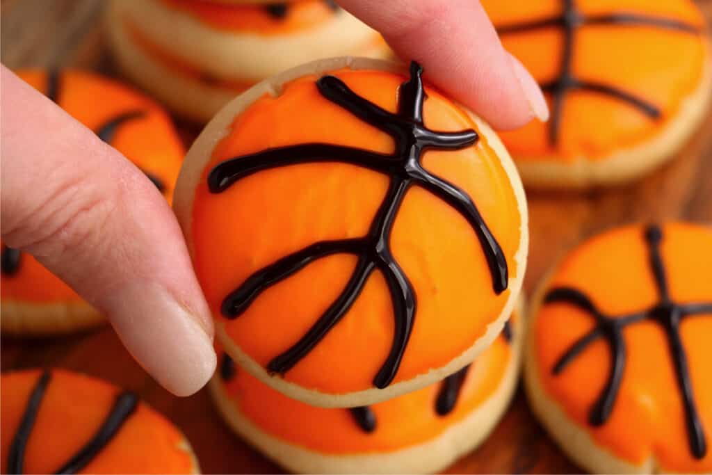 Closeup shot of hand holding basketball sugar cookie.