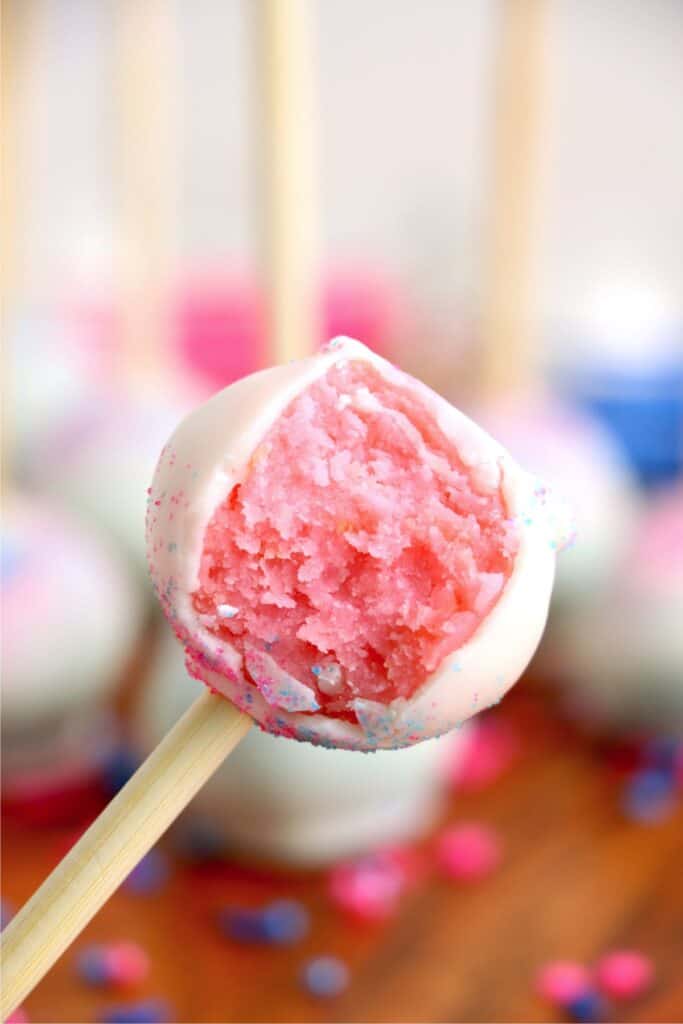 Closeup shot of pink gender reveal cake pop with bite taken out