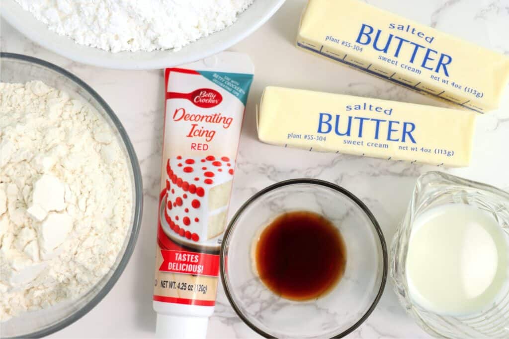 Overhead shot of baseball sugar cookie ingredients in individual bowls on table