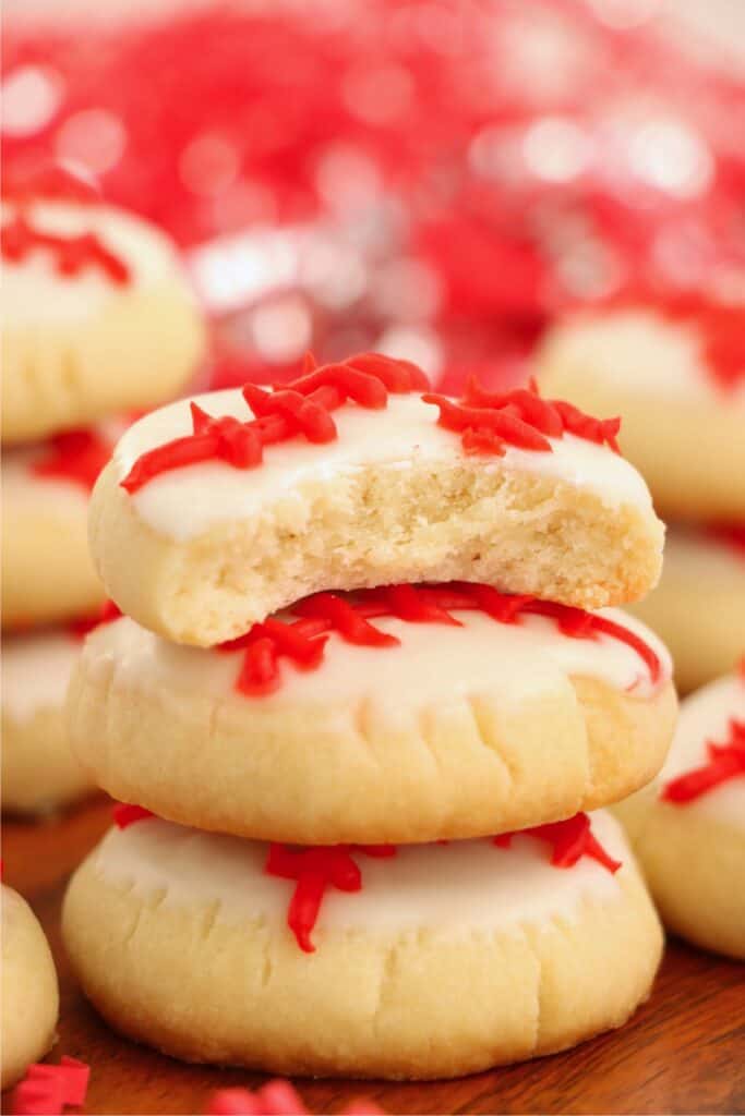 Closeup shot of baseball sugar cookies stacked atop one another with bite taken out of top cookie