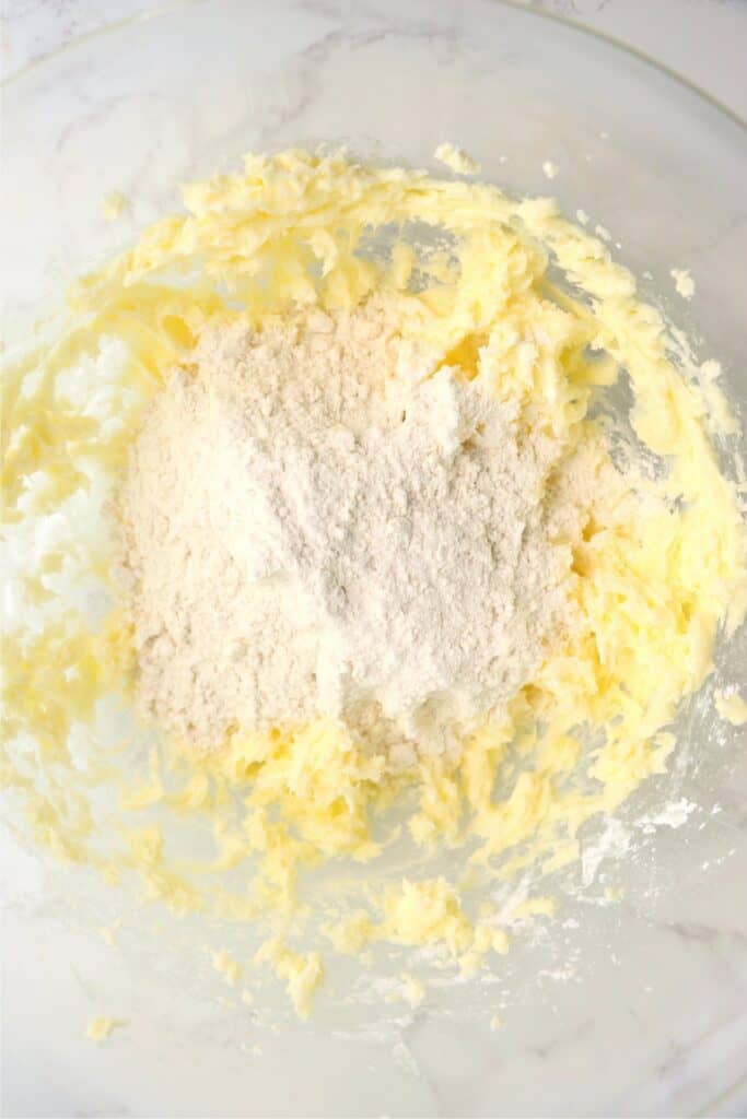 Overhead shot of mixing bowl with creamed butter and sugar along with flour