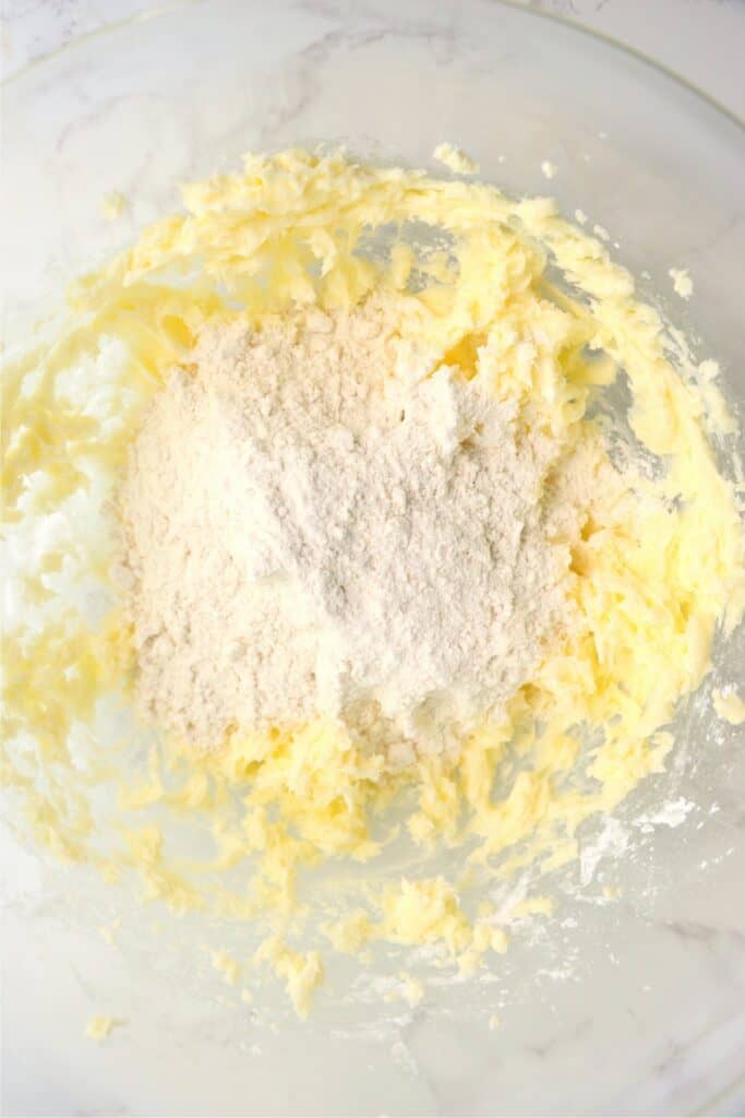 Overehead shot of flour and creamed butter and sugar in mixing bowl