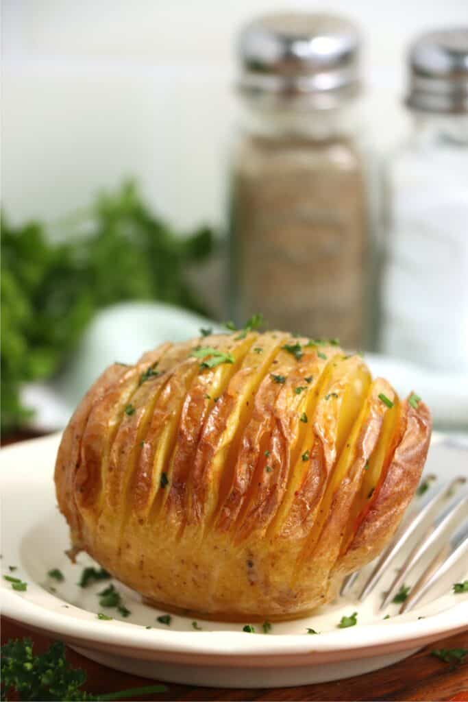 Closeup shot of air fryer Hasselback potato on plate.