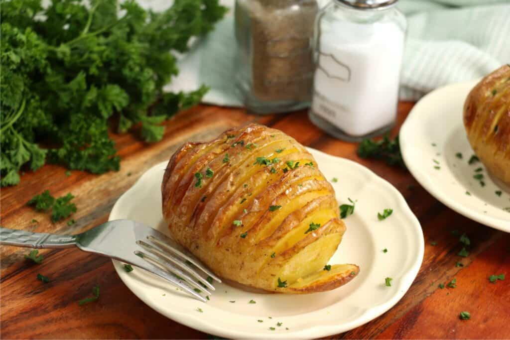 Closeup shot of air fryer Hasselback potato on plate.