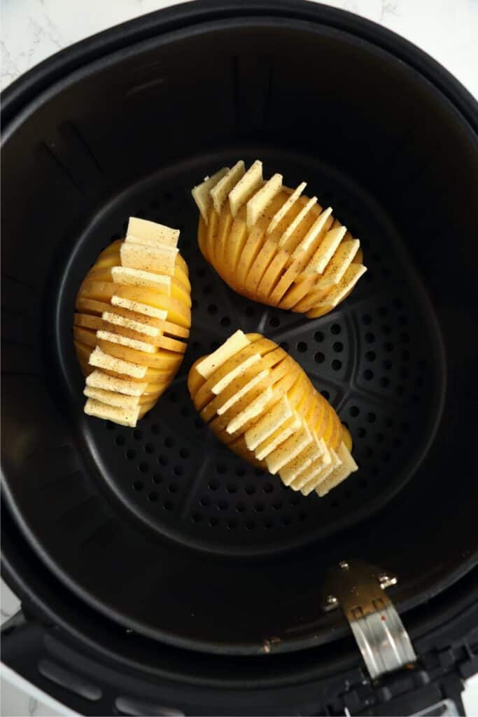 Overehead shot of unaked Hasselback potatoes in air fryer basket