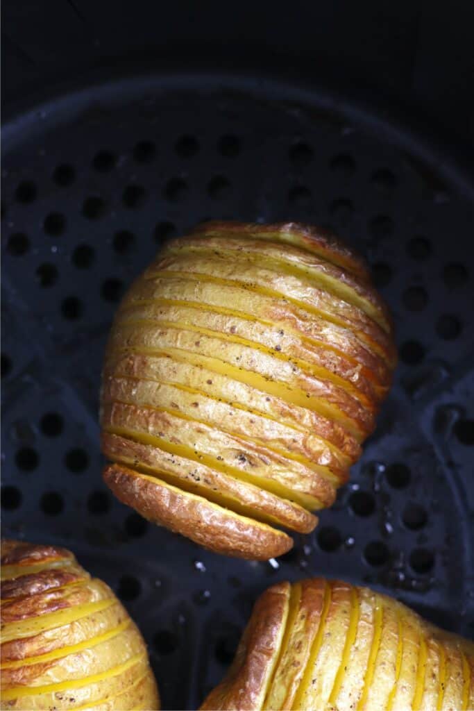 Closeup shot of air fryer Hasselback potatoes in air fryer basket