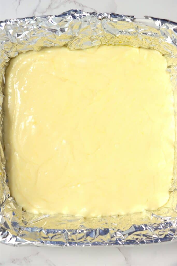 Closeup overhead shot of banana fudge mixture in baking dish lined with foil