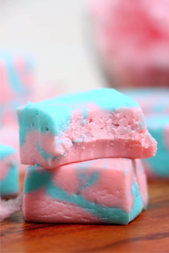 Closeup shot of two cotton candy fudge squares stacked atop one another with bite taken out of top square