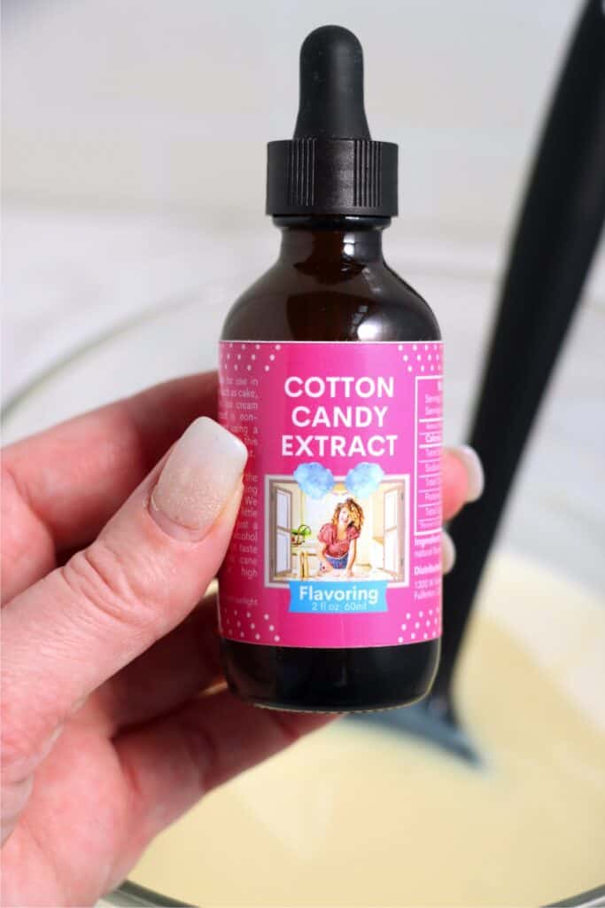 Closeup shot of hand holding bottle of cotton candy extract.