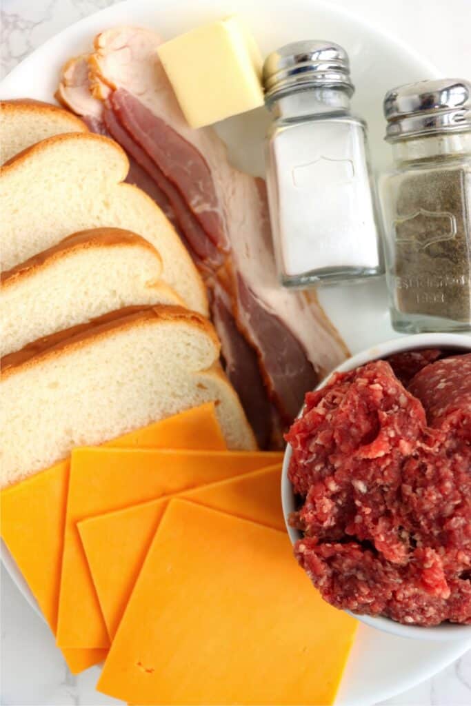 Overhead shot of grilled cheese bacon hamburger ingredients on plate