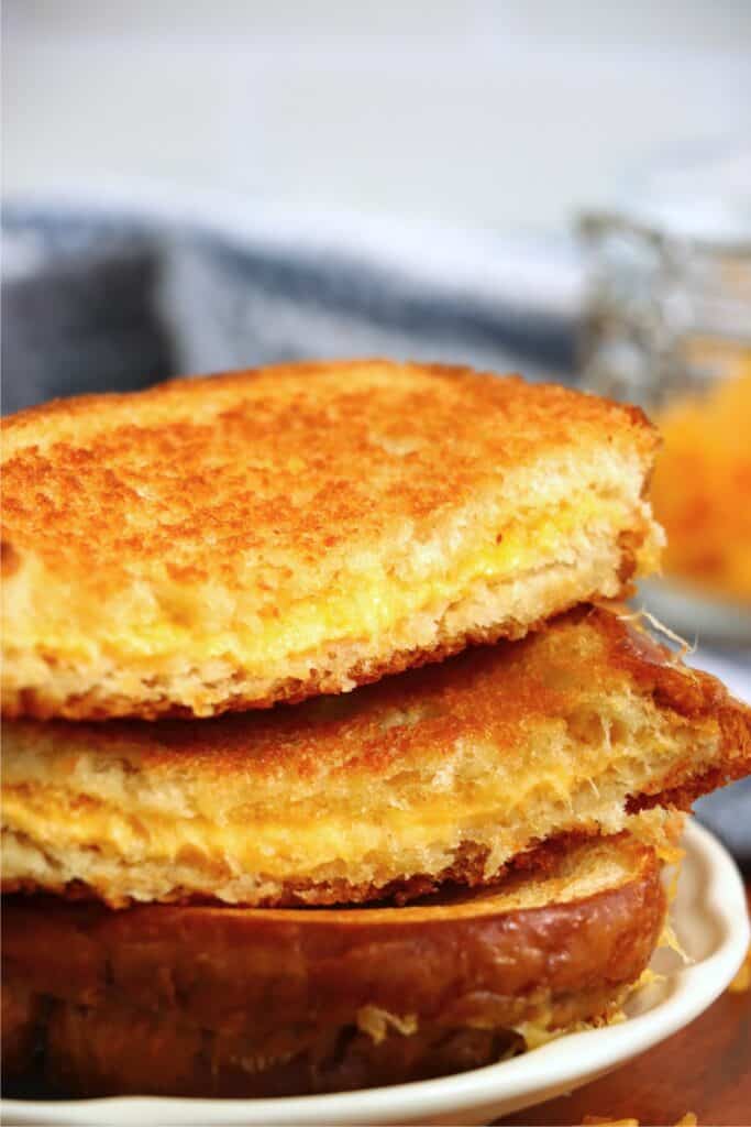 Closeup shot of oven baked grilled cheese halves stacked atop one anothe ron plate