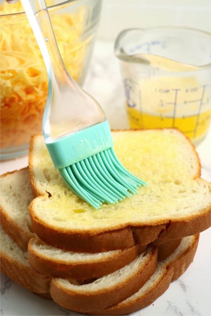 Closeup shot of melted butter being brushed on bread