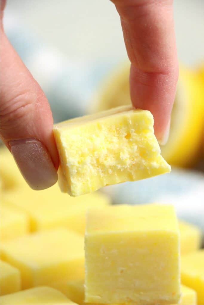 Closeup shot of hand holding lemon fudge square.