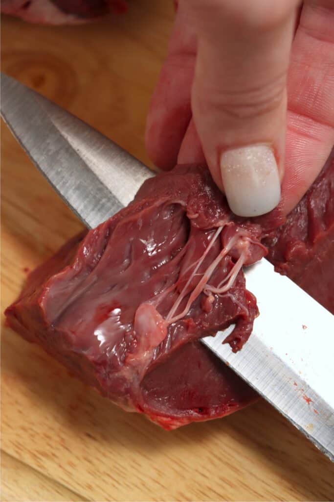 Closeup shot of venison heart membraine being cut away with knife