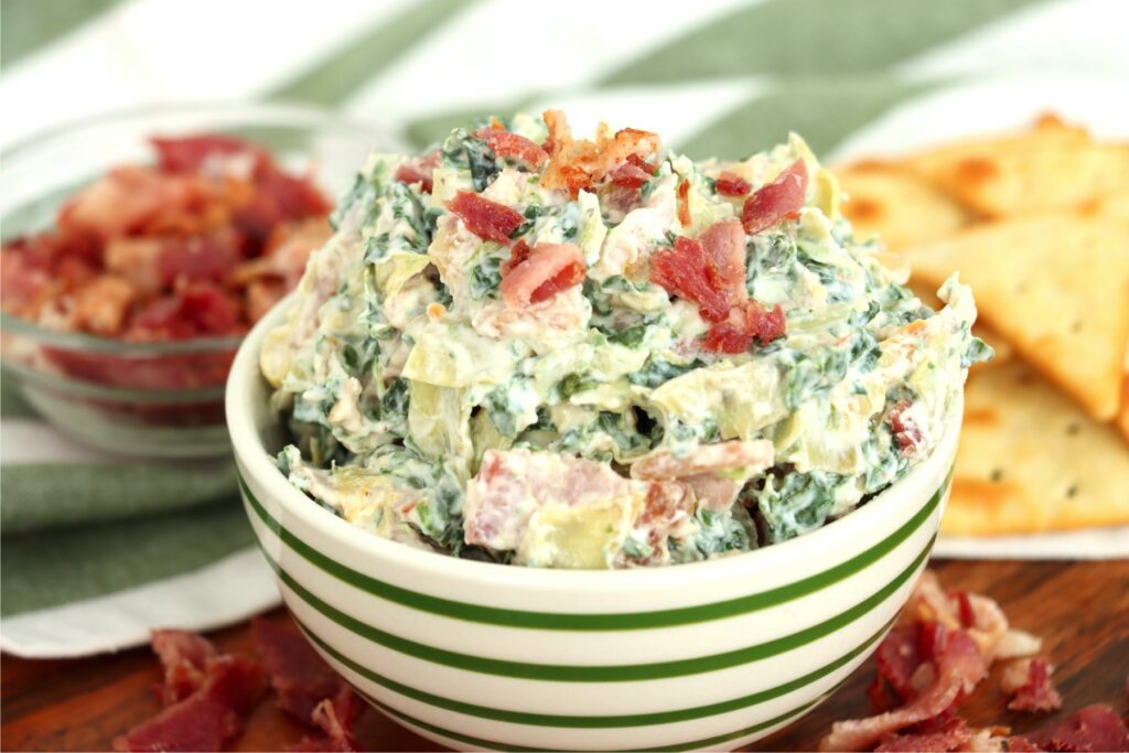Bowlful of spinach artichoke dip with bacon
