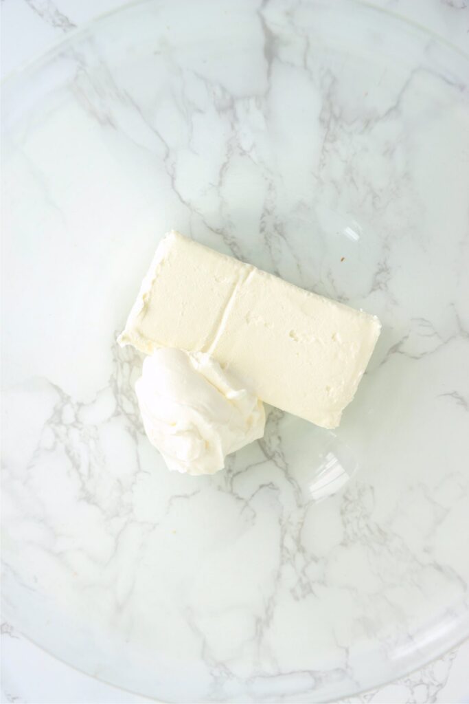 Overhead shot of cream cheese and sour cream in mixing bowl