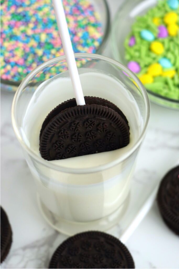 Oreo on stick being dipped into melted almond bark