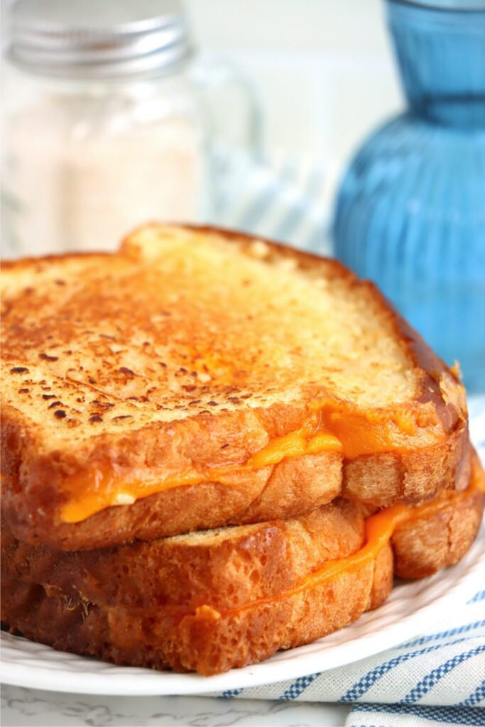 Closeup shot of two garlic grilled cheese sandwiches stacked atop one another on plate