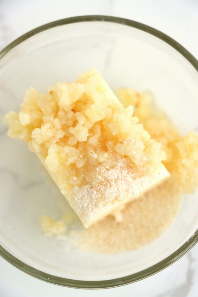 Closeup shot of butter, minced garlic, and garlic salt in bowl.